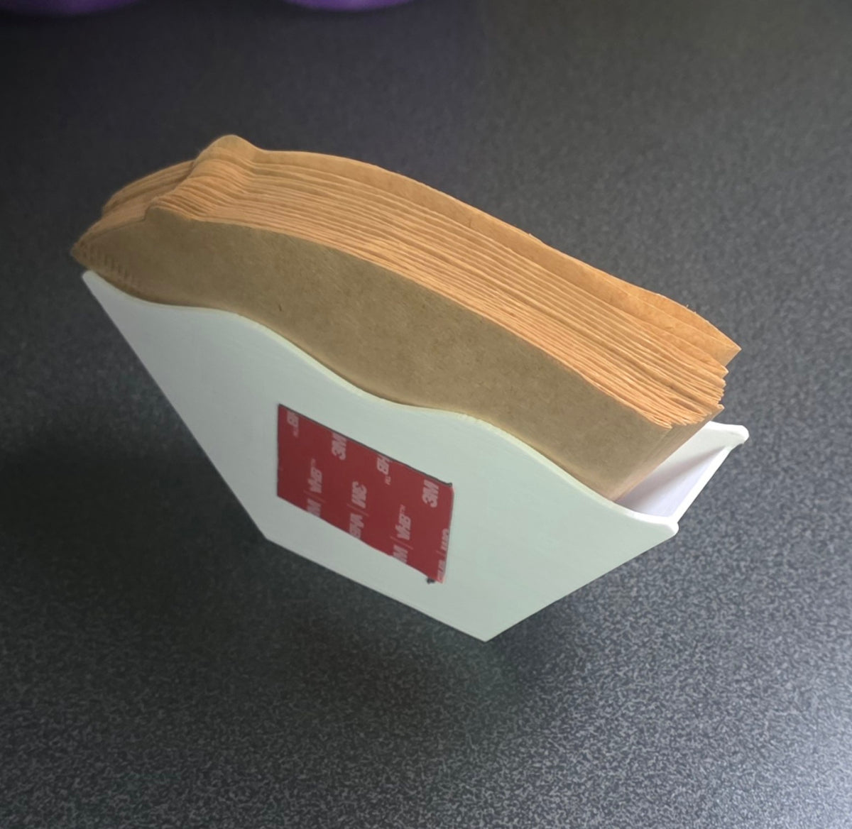 Gefüllter weißer Kaffeefilterhalter mit Kaffeebohnenmuster, Rückseite mit Klebepad.